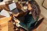 Woman working at a desk with laptop and tablet.